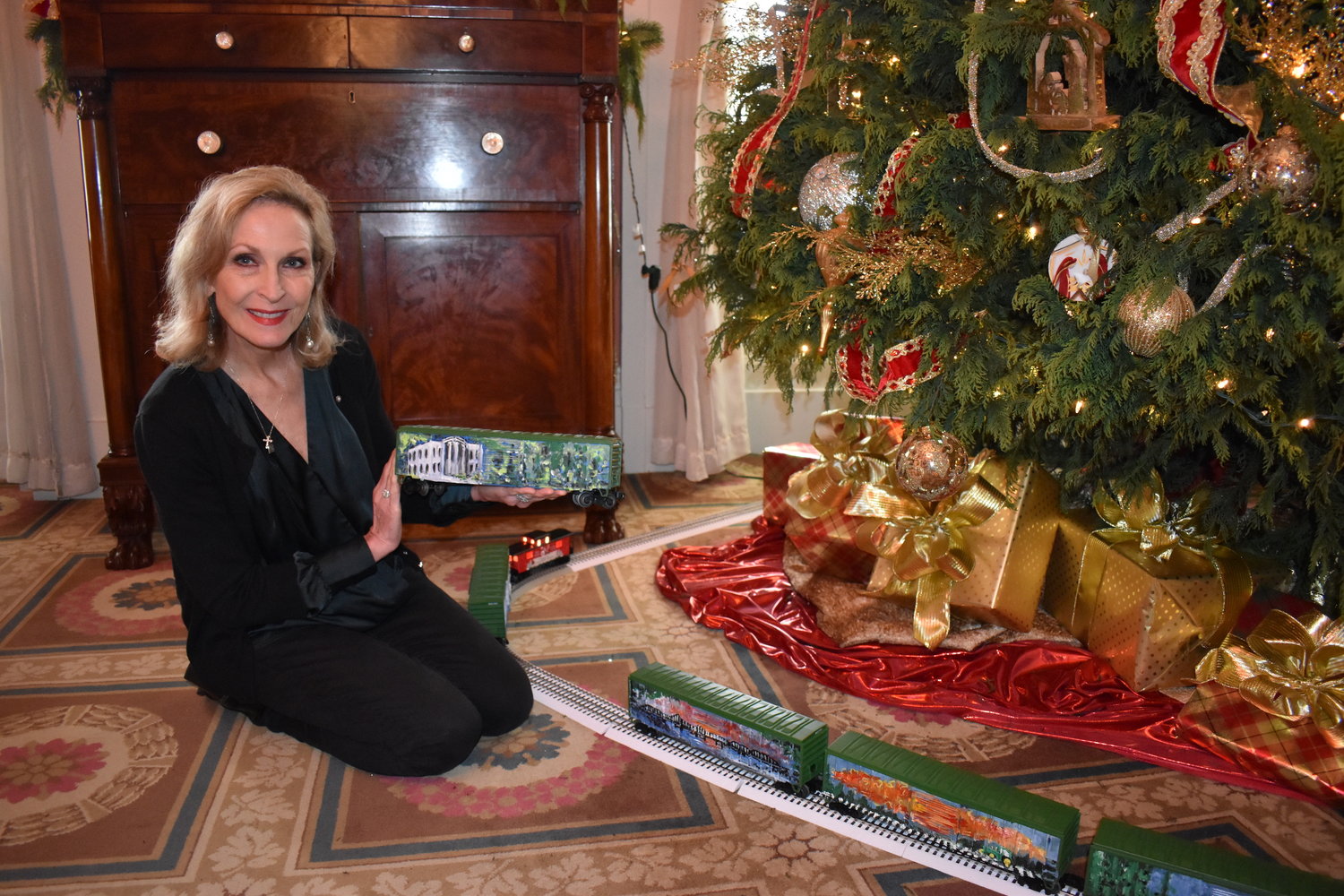 Ann Phillips Beard, a Madison artist and chief of staff to First Lady Elee Reeves, painted a Mississippi Christmas train for the Christmas tree in the Rose Room at the Governor’s Mansion. Each of the six trees at the Mansion has a toy train circling its base.